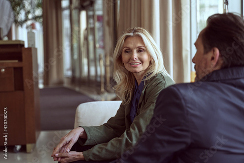 Beauitful lady and a handsome man sitting down in a hotel waiting area