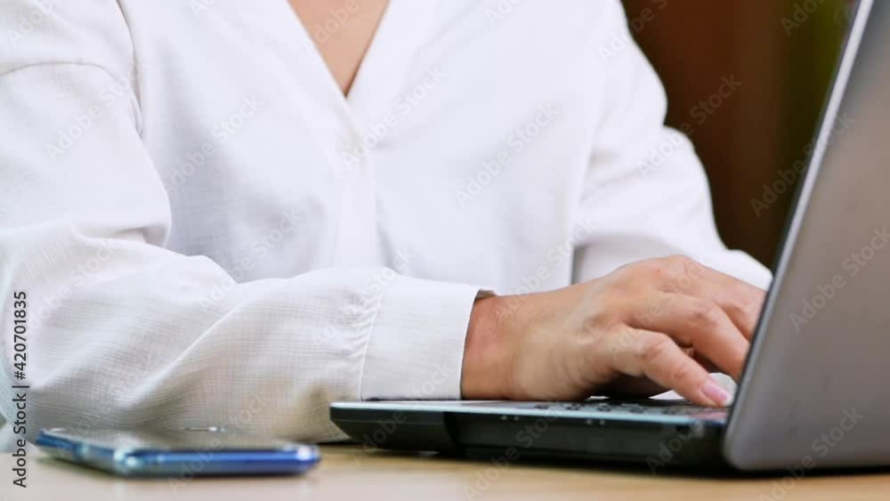 Business woman suffering from wrist pain while working on laptop computer in office. Business woman suffering from wrist pain while working on laptop computer in office.