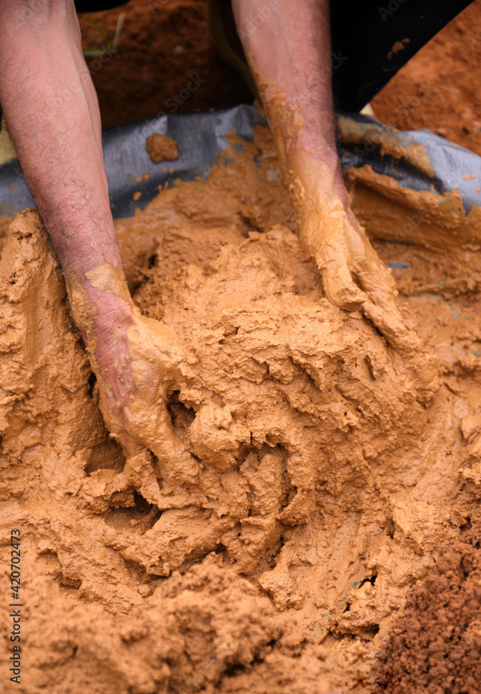 Close up the mud stirred by both hands, ready to be used as the material for the roast pheasant. Close up the mud stirred by both hands, ready to be used as the material for the roast pheasant.