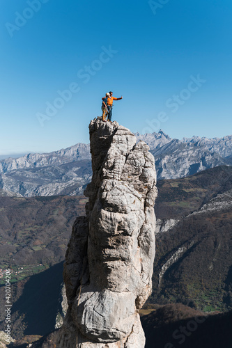 Mountain guide and client taking selfie on top of pinnacle