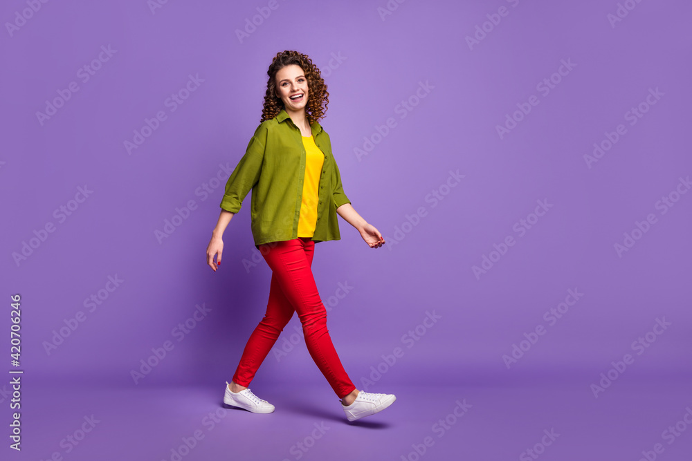 Full size profile side photo of young lovely pretty sweet smiling girl go walk wear colorful outfit isolated on purple color background