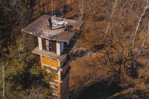 Aerial drone view of daredevils on the top of an abandoned ski jumping hill in siska, slovenia. dangerous maneouvres and stunts on buildings. photo