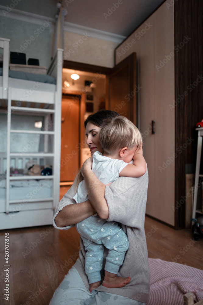 A young happy mother holds a baby in her arms. A young happy mother holds a baby in her arms.