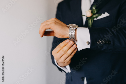 Man in suit adjusting watch photo