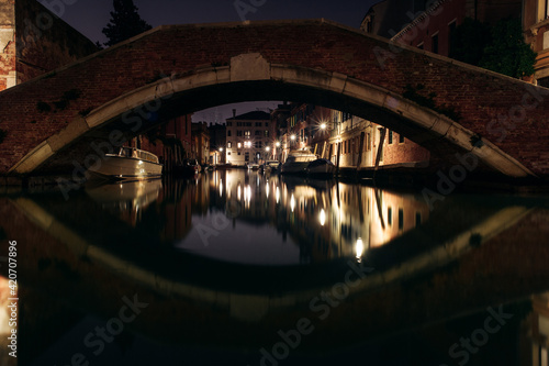 Colourful Venice Canal seen through the bridge and it's reflection