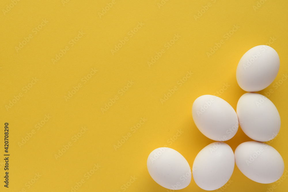 Fresh eggs on yellow background.