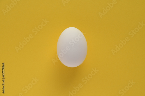 Fresh egg on yellow background.