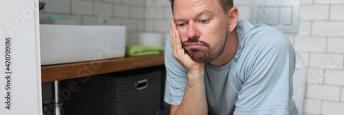 Man sit on toilet with constipation and wait for laxative to take effect.