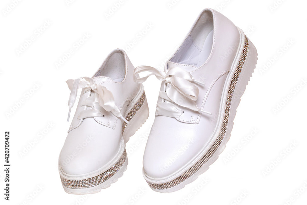 White sneaker isolated. Close-up of a pair white elegant stylish female leather high-heeled sport shoes isolated on a white background. Womens shoe fashion 2020. Modern design footwear for workout. White sneaker isolated. Close-up of a pair white elegant stylish female leather high-heeled sport shoes isolated on a white background. Womens shoe fashion 2020. Modern design footwear for workout.