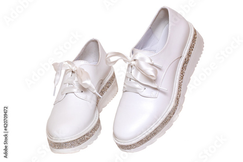White sneaker isolated. Close-up of a pair white elegant stylish female leather high-heeled sport shoes isolated on a white background. Womens shoe fashion 2020. Modern design footwear for workout.