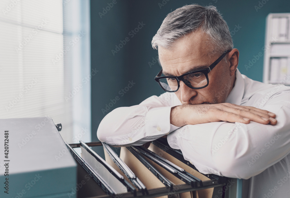 Businessman searching for files in the office - obrazy, fototapety, plakaty 