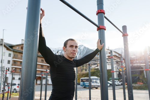 Sportsman resting near bars on sports ground photo