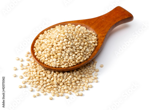 uncooked white quinoa, in the wooden spoon, isolated on pure white background