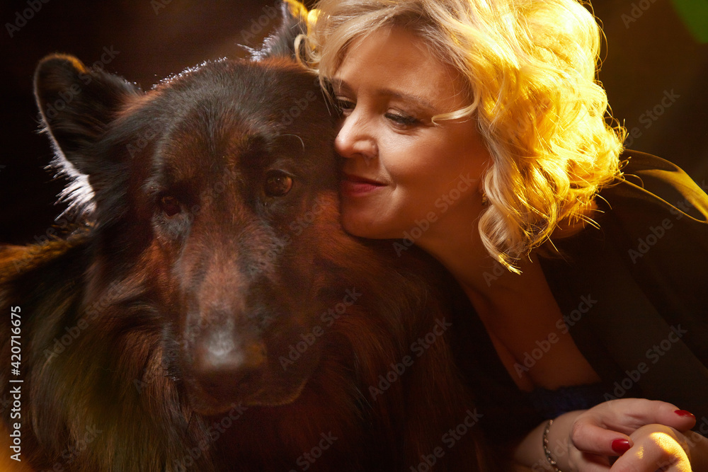 Cute blonde woman and dog german shephers posing during studio photo shot.  Tender relations and friendship of a girl and an animal Stock Photo | Adobe  Stock