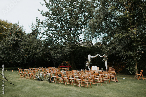 Beautiful outdoor wedding ceremony set up with wooden folding chairs