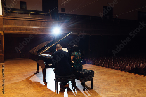 Man and woman, playing a piano photo