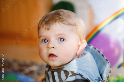 Portrait of little child, cute adorable baby boy playing with colorful toys. Happy, curious kid at home, indoors.