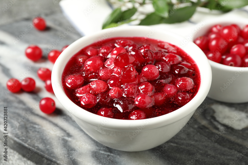 Fresh cranberry sauce in white bowl on marble board