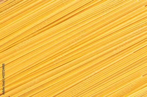 Raw dry spaghetti italian pasta spaghetti line texture yellow long spaghetti background. Concept food background.