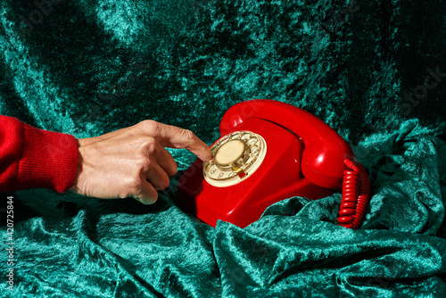 man dialing on a red telephone
