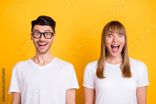 Photo of shocked funny two people dressed white t-shirt glasses open mouth isolated yellow color background