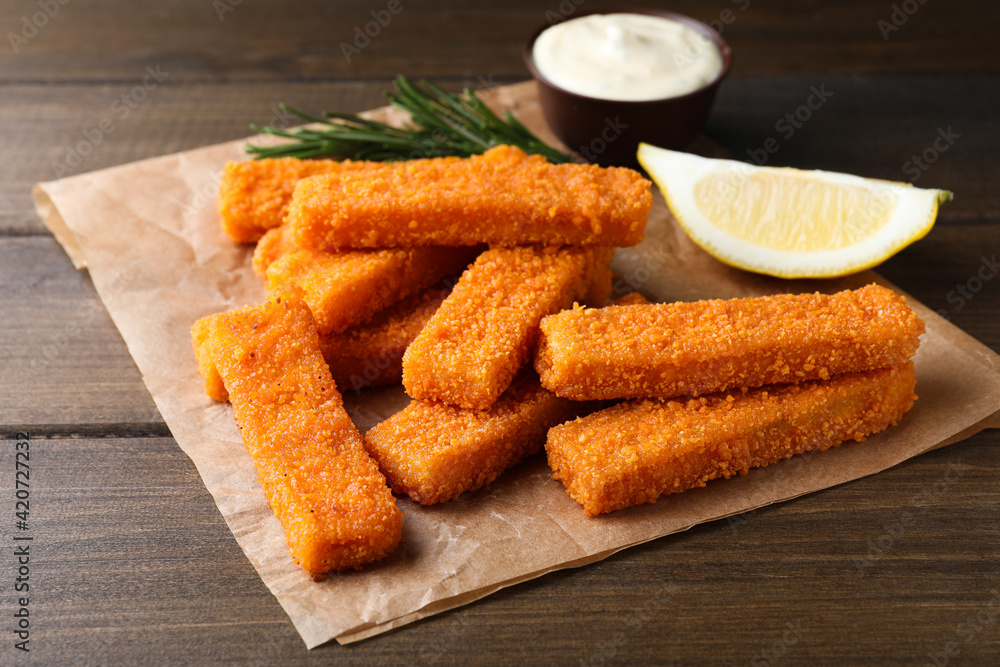 Fresh breaded fish fingers served on wooden table Fresh breaded fish fingers served on wooden table