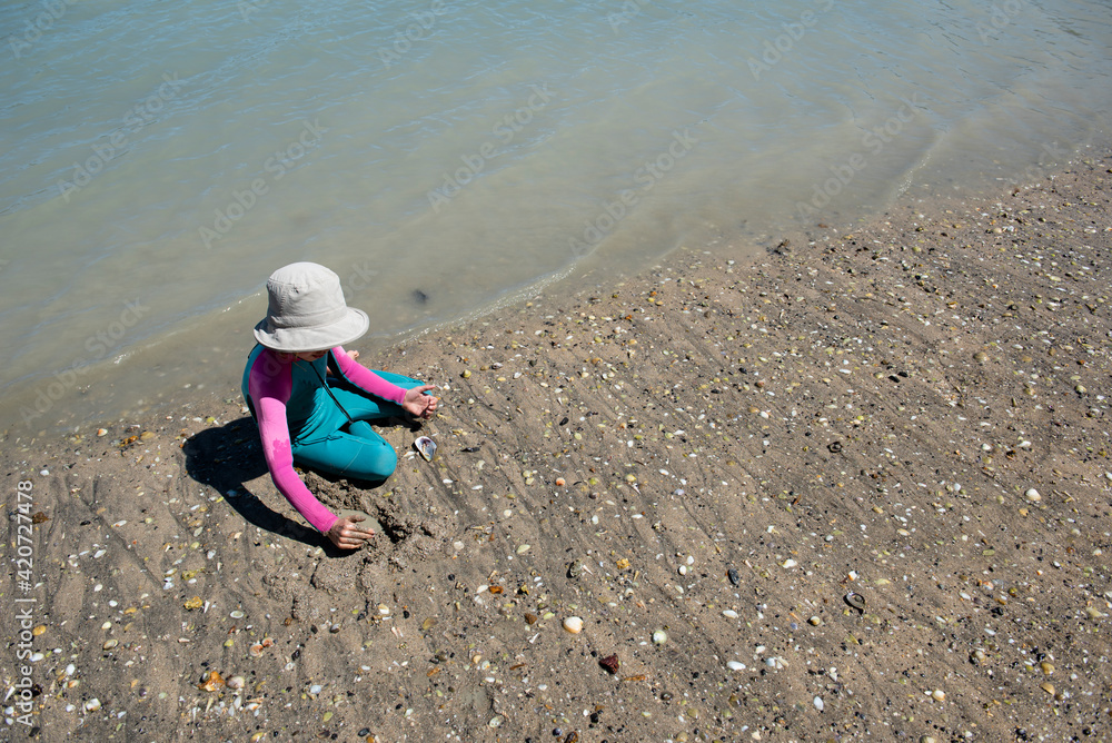 Girl in a wetsuite, playing at the water's edge, Quail Island. Girl in a wetsuite, playing at the water's edge, Quail Island.