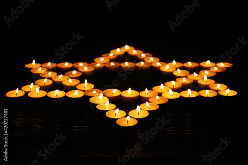 Star of David made with burning candles on black background. Memory day photo