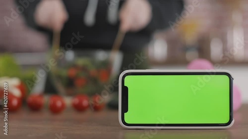 Wallpaper Mural Healthy lifestyle mockup. Smartphone with green screen chroma and person preparing a vegan salad with vegetables at home. Torontodigital.ca