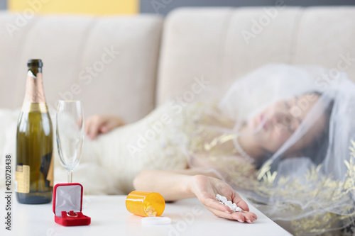 Bride lying on couch with handful of pills in her hand closeup
