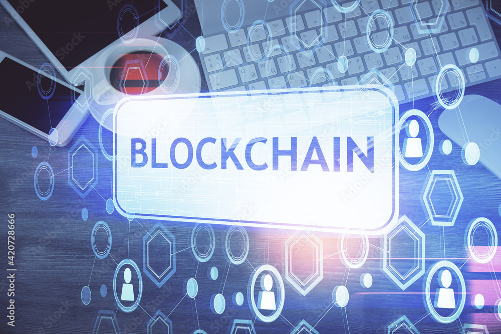 Double exposure of blockchain theme hologram over table with phone. Top view. Crypto technology concept. Double exposure of blockchain theme hologram over table with phone. Top view. Crypto technology concept.