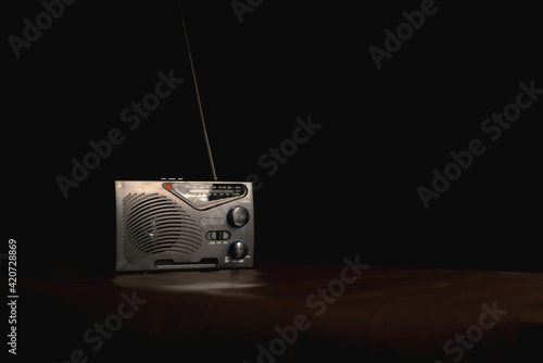 Transistor radio on the table in black backdrop.