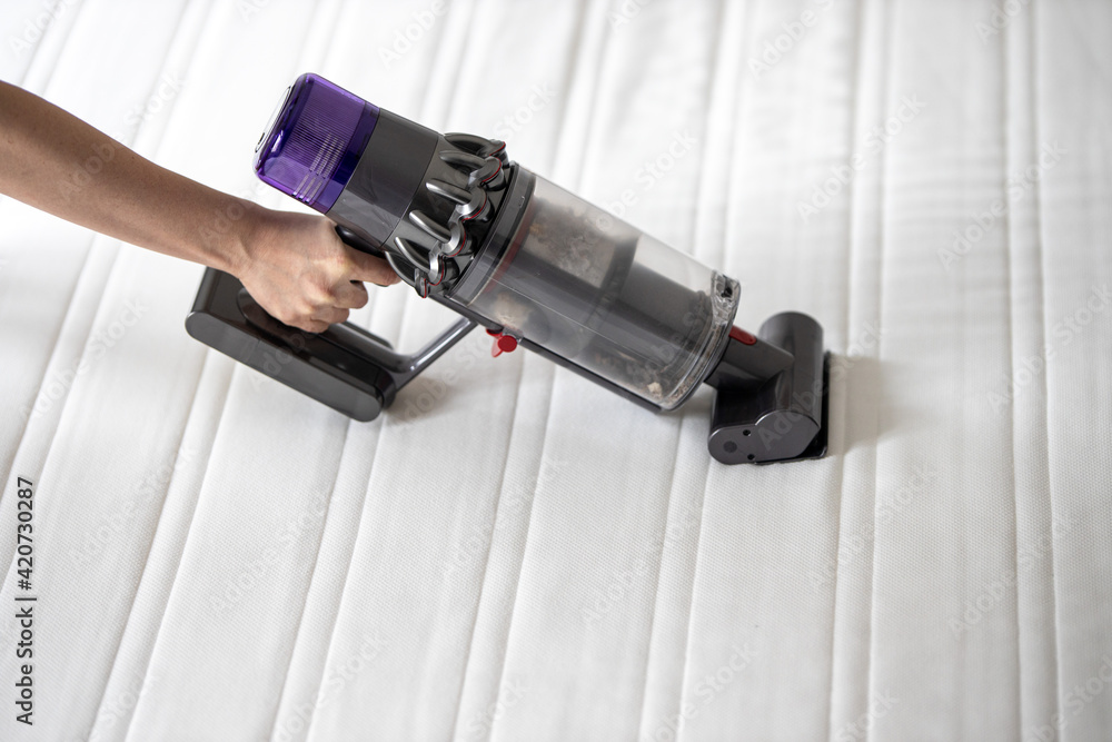 Frühjahrsputz im Schlafzimmer, Staubsauger saugt die Matratze ab und befreit sie so von Milben Frühjahrsputz im Schlafzimmer, Staubsauger saugt die Matratze ab und befreit sie so von Milben