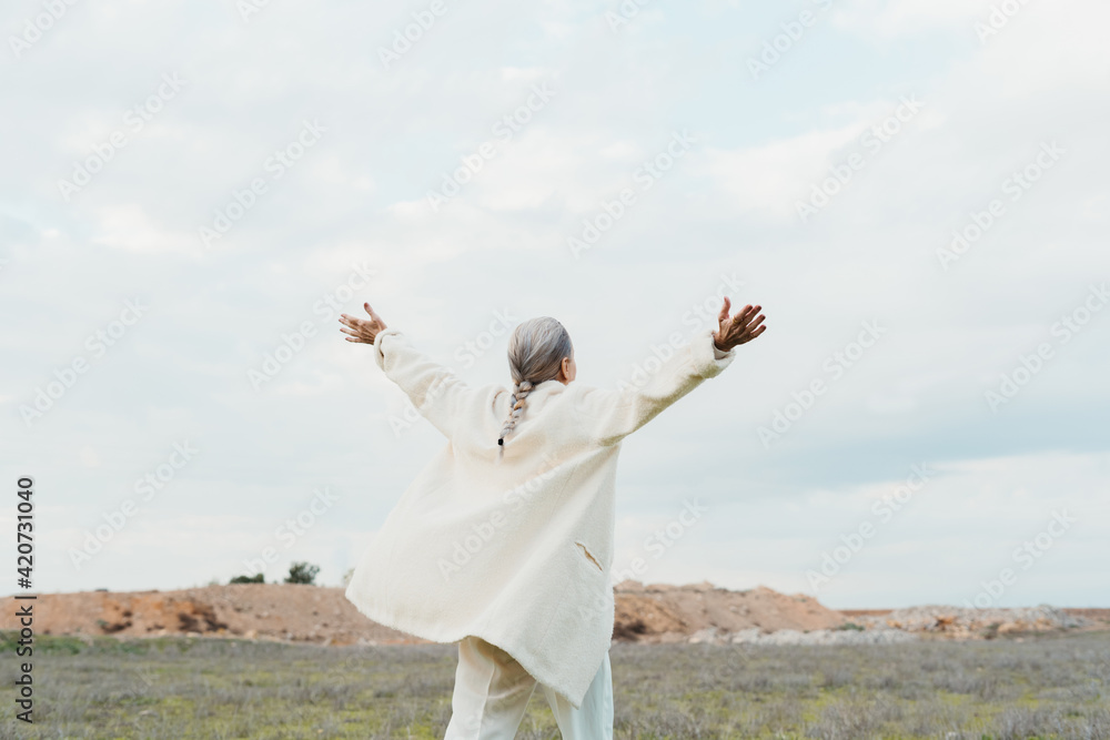 senior woman with open arms relaxing and feeling free at field senior woman with open arms relaxing and feeling free at field