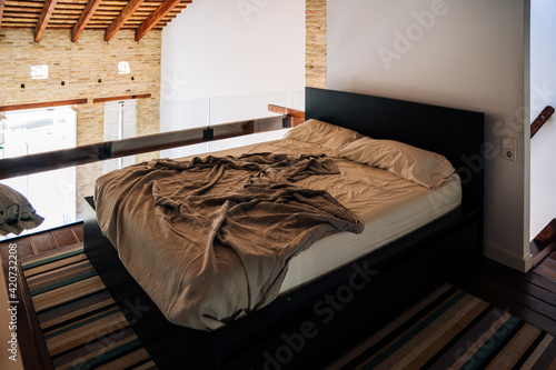 Unmade bed in modern apartment photo