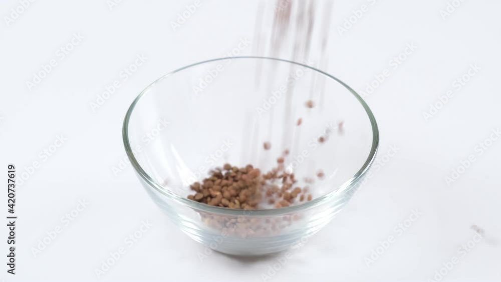 Green lentils in a glass bowl on white background. Healthy organic food diet concept. Fresh natural food ingredient, slow motion Green lentils in a glass bowl on white background. Healthy organic food diet concept. Fresh natural food ingredient, slow motion