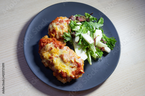 Obraz na plátně Chicken parmigiana with salad on the side.
