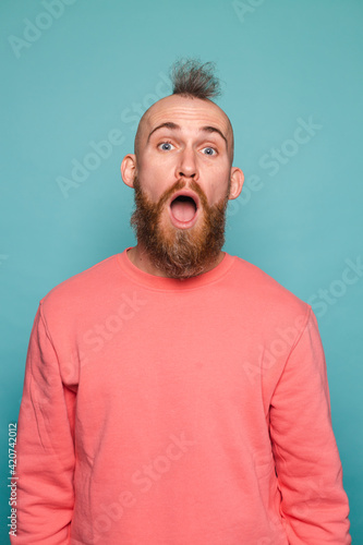 Bearded european man in casual peach isolated on turquoise background shocked with surprise expression, fear and excited face