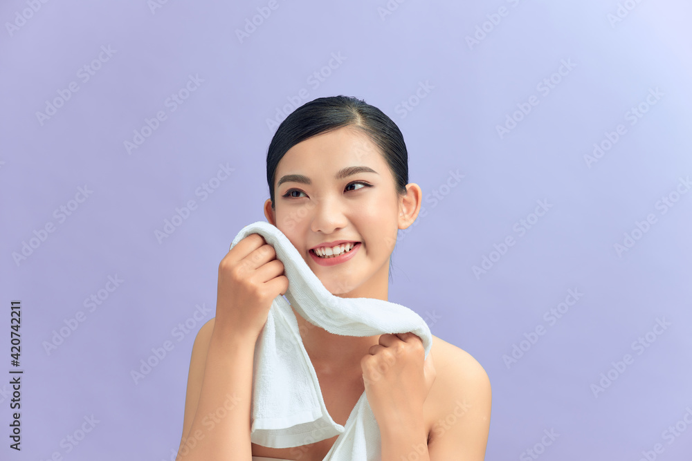 Woman cleaning facial skin with towel after washing face portrait Woman cleaning facial skin with towel after washing face portrait
