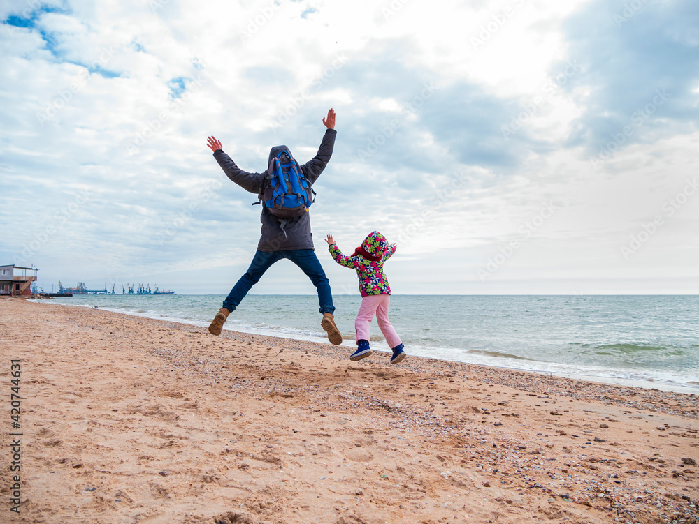 Father and daughter jumping flying in the air on empty beach. Lifestyle photo real people. Scenic marine landscape Vivid blue sea water sky. Happy active family having fun on vacation travel wallpaper Father and daughter jumping flying in the air on empty beach. Lifestyle photo real people. Scenic marine landscape Vivid blue sea water sky. Happy active family having fun on vacation travel wallpaper