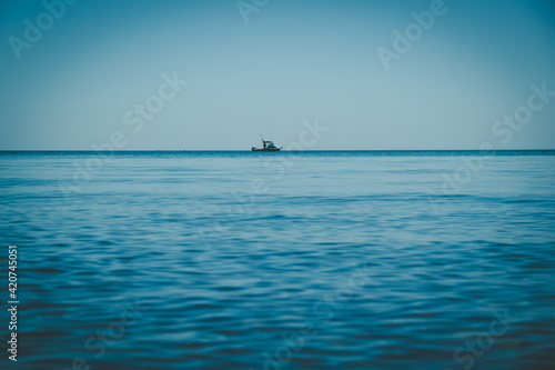 Small fishing boat on the horizon - minimalist seascape with copy space © Greg Brave