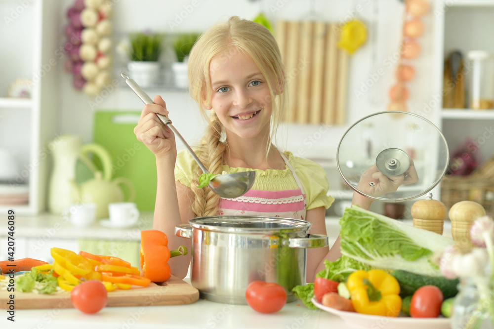 Cute happy girl coocking  soup on  kitchen