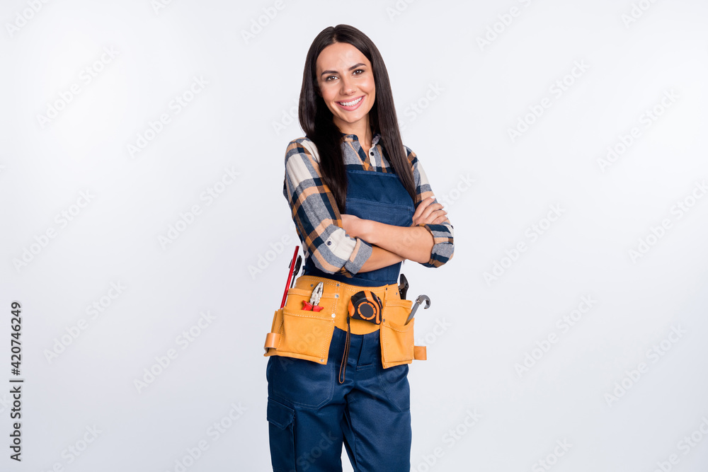 Photo of happy smiling cool confident girl in builder uniform with folded hands professional isolated on white color background Photo of happy smiling cool confident girl in builder uniform with folded hands professional isolated on white color background