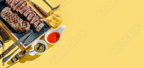 Obraz na płótnie two strip steaks in medium rare fried on a yellow background. dinner concept for two w salonie