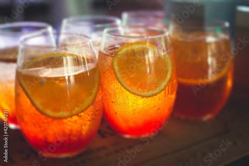 Row line of red colored negroni and spritz aperitif alcohol cocktails on a party of alcohol setting on catering banquet table, vodka, and others on decorated catering table event with bartender