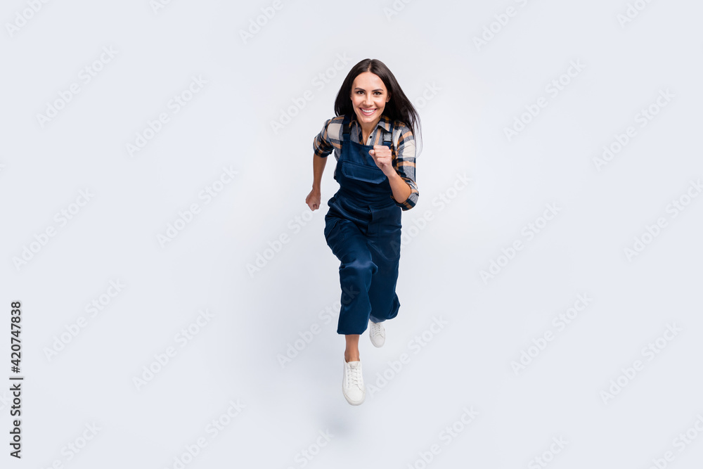 Full size photo of happy smiling pretty woman builder running in air fast speed isolated on white color background Full size photo of happy smiling pretty woman builder running in air fast speed isolated on white color background