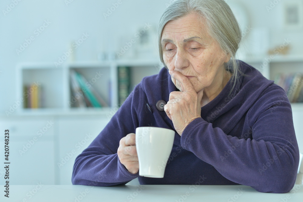 sad old woman with headache drinking tea sad old woman with headache drinking tea