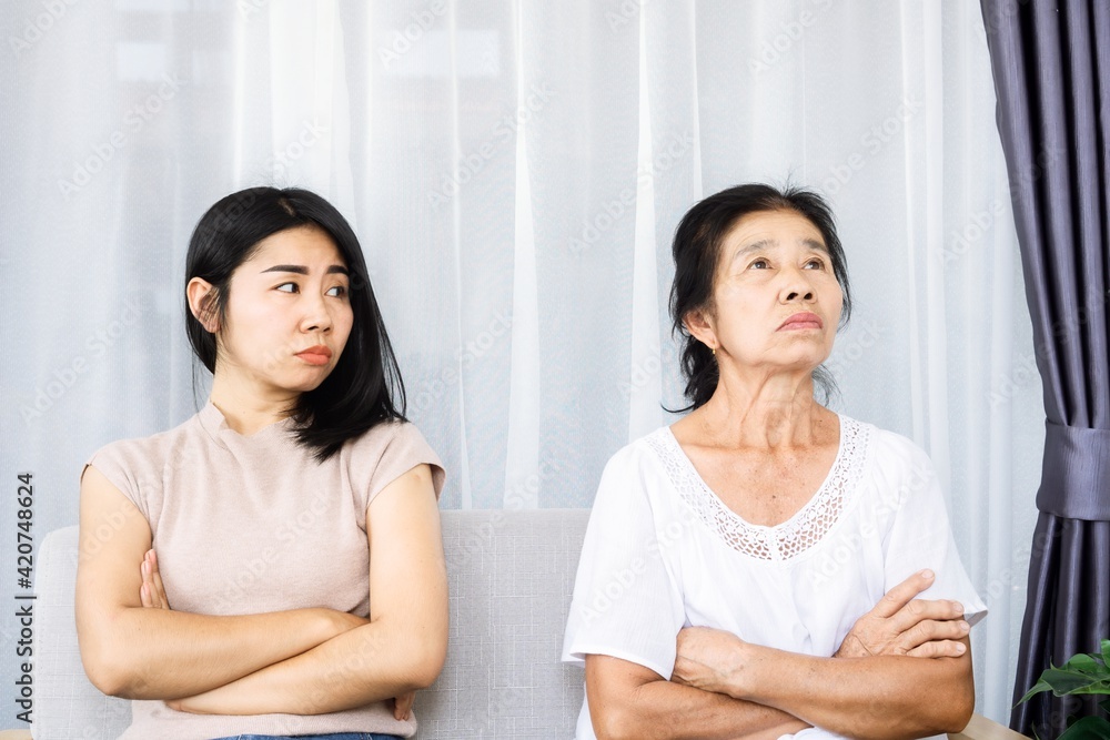old senior Asian mother angry and ignoring her young daughter, daughter tired with annoyed mom quarrel in family concept old senior Asian mother angry and ignoring her young daughter, daughter tired with annoyed mom quarrel in family concept