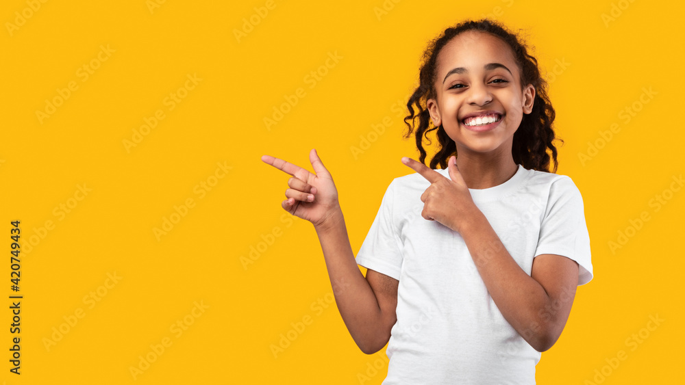 Excited black girl pointing aside at free copy space Excited black girl pointing aside at free copy space