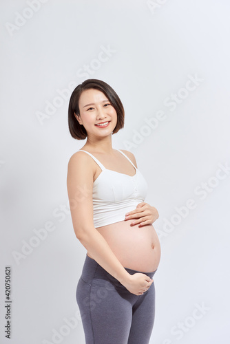 Beautiful asian pregnant woman expecting baby and touching her belly